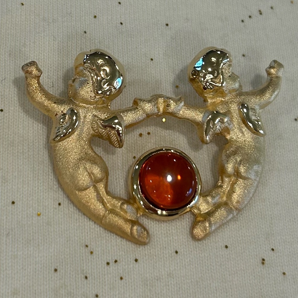 New Vintage Louis Stern (LS) gold-tone cherub brooch with a faux amber cabochon.